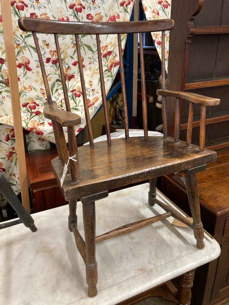 An early 19th century, possibly Welsh ash and fruitwood primitive Windsor comb back elbow chair, width 59cm, depth 40cm, height 90cm